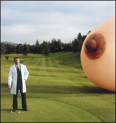 Dr. Garth Fisher playing golf next to giant breast on grass
